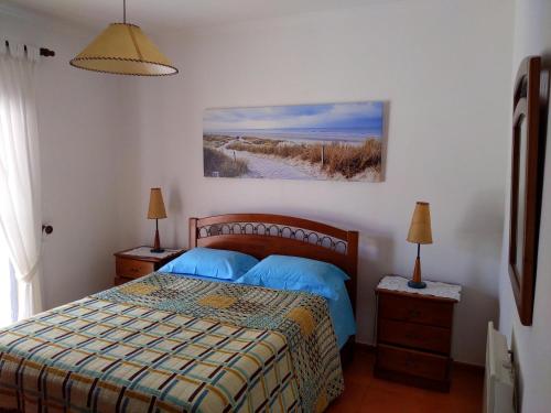 1 dormitorio con 1 cama y una pintura en la pared en Comporta beach house, en Carvalhal