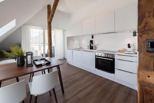 a kitchen with white cabinets and a wooden table at Lunas Appartements in der alten Schule Essen in Essen