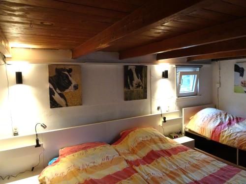 een slaapkamer met twee bedden en twee foto's aan de muur bij B&B Verwoldsehof 'Op de deel' in Laren