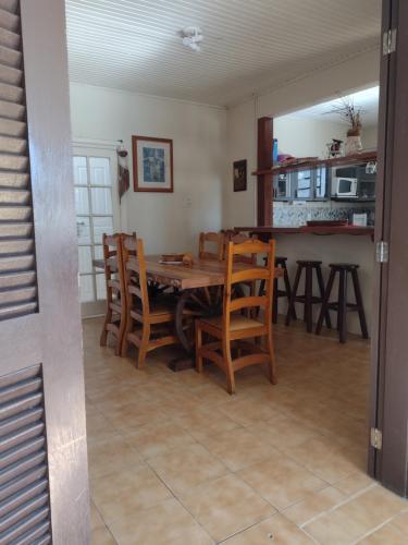 Casa no centro em Garopaba في غاروبابا: مطبخ وغرفة طعام مع طاولة وكراسي