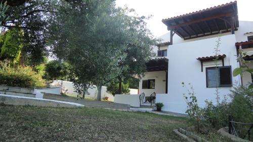 una casa blanca con un patio delante en Casa De Vacacion, en Gerakini