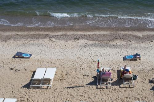 a group of people sitting in lawn chairs on the beach at Falmouth Tides in Falmouth