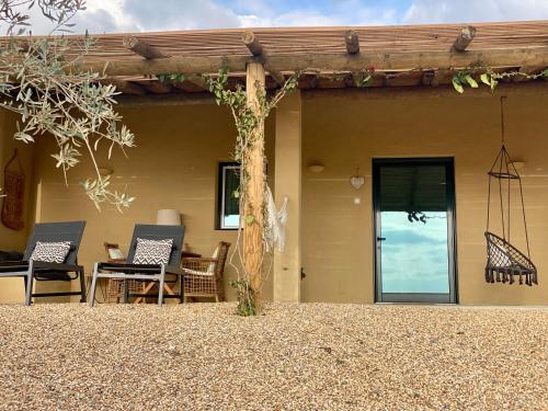 a house with a patio with chairs and a door at Monte da Aparica in Galeguinha Grande