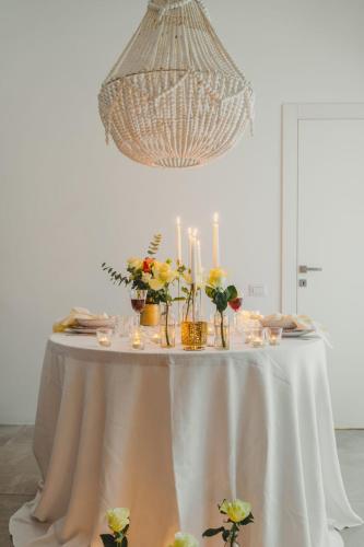 a white table with candles and flowers on it at Nest House & Relax in Civitanova Marche