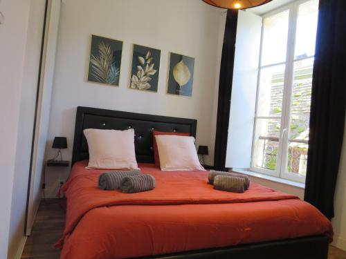 um quarto com uma cama com lençóis e almofadas laranja em La Lauzeta em Sarlat-la-Canéda