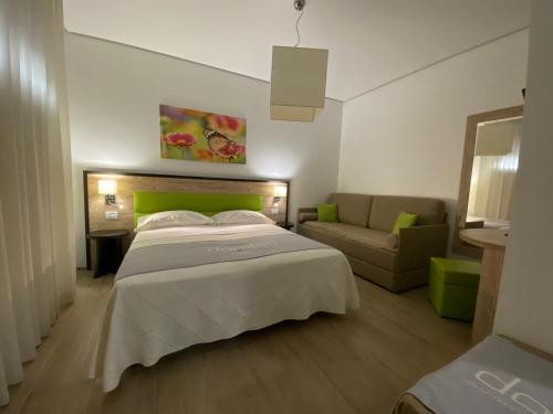 une chambre d'hôtel avec un lit et un canapé dans l'établissement B&B Vanessa, à Alba Adriatica