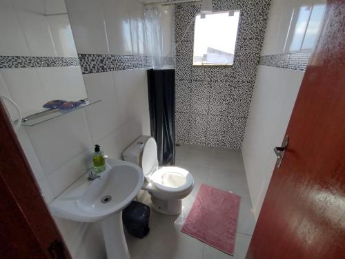La petite salle de bains est pourvue de toilettes et d'un lavabo. dans l'établissement Apartamento da Rosi, à Resende