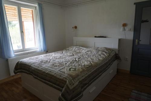 una camera da letto con un letto con un piumone e una finestra di Holidays Hongarije a Igal