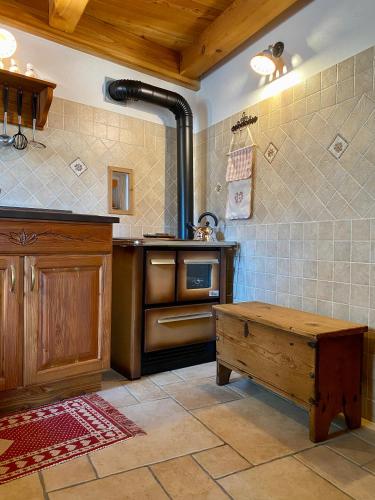 Il comprend une cuisine équipée d'une cuisinière et d'une table en bois. dans l'établissement Baita di Charme Le Petit Chanton - CIR 0016, à Gaby