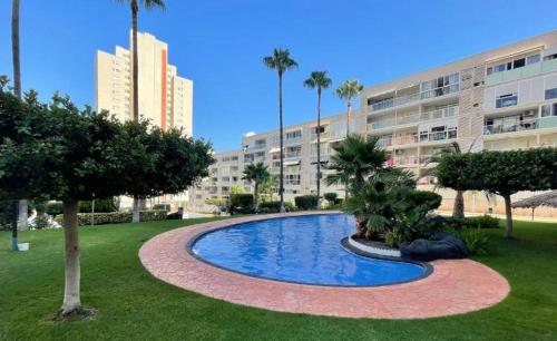 basen przed budynkiem z palmami w obiekcie Torres Montecarlo Apartmento con vistas al mar w mieście Benidorm