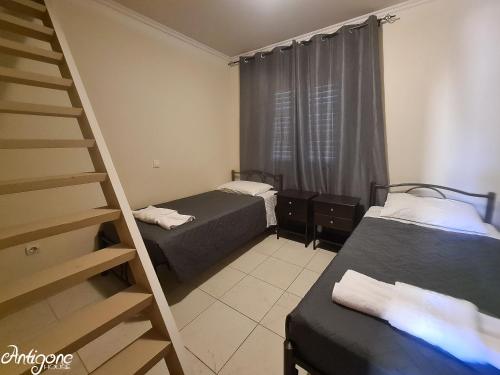 Cette petite chambre comprend deux lits et une échelle. dans l'établissement Antigone House, à Agios Stefanos