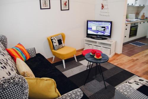 a living room with a couch and a tv at Apartman Sunčica in Lukavica