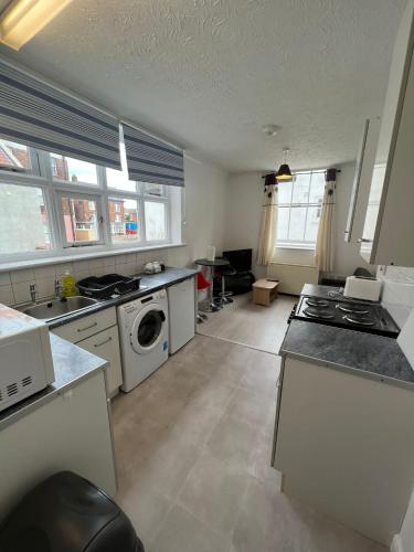 een grote keuken met een wasmachine en droger. bij Entire One Bedroom Flat, 5 in Great Yarmouth
