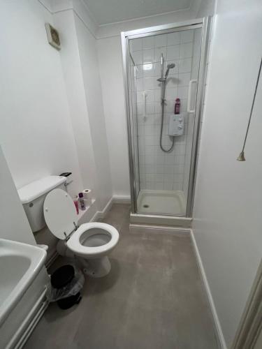 a white bathroom with a shower and a toilet at Entire One Bedroom Flat, 5 in Great Yarmouth