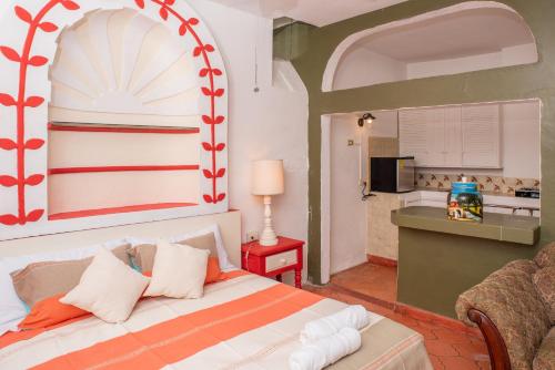 a bedroom with a bed and a kitchen at The Bersal House Flats in San Miguel de Allende