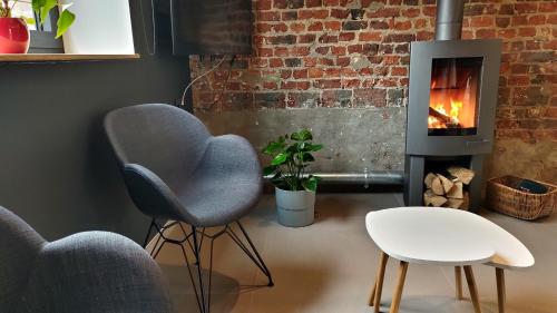 a living room with two chairs and a fireplace at Gîte La Siroperie in Wanze