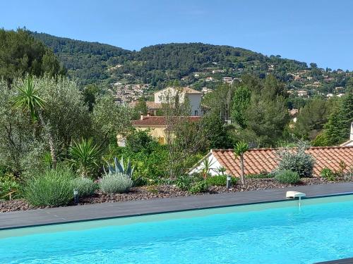 une piscine devant une maison avec une montagne dans l'établissement villa contemporaine de charme avec grande piscine, au Beausset