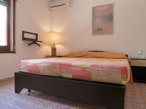 a bedroom with a bed in a room with a lamp at Cottage LeDune profumi mediterranei vicino al mare in Torre Rinalda