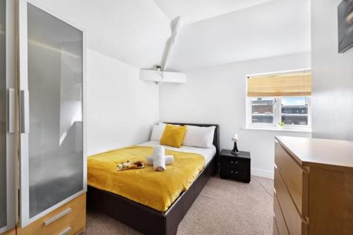 a bedroom with a bed with a yellow blanket at Heart of City Centre - Newcastle in Newcastle upon Tyne