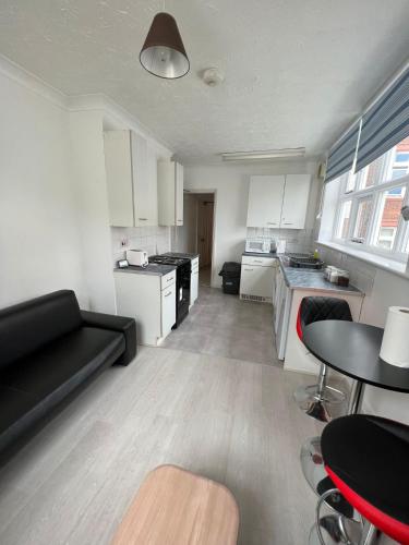 a living room with a black couch and a kitchen at Entire One Bedroom Flat, 5 in Great Yarmouth