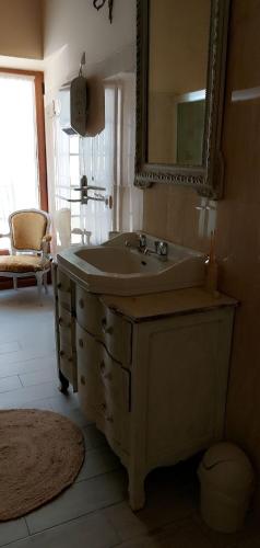 une salle de bain avec un lavabo et un miroir dans l'établissement La Grange, Le Domaine de Brugal, à Carsac-Aillac