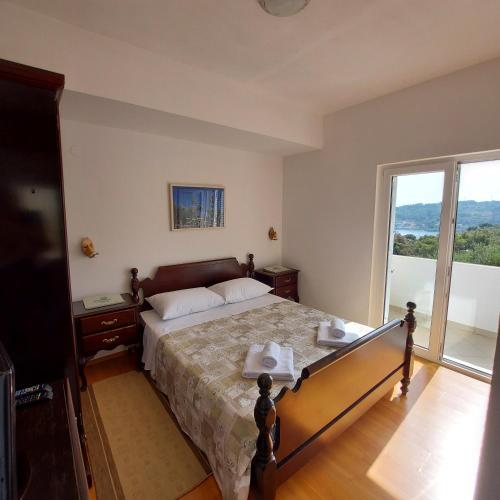 a bedroom with a bed and a large window at Villa Šolta - b&b overlooking the bay in Rogač