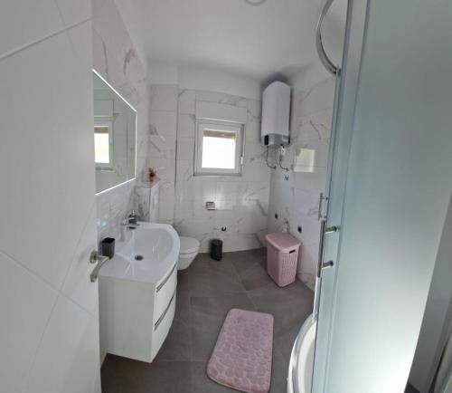 a white bathroom with a sink and a toilet at Apartments Luce - Dome in Split