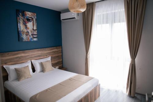 a bedroom with a bed and a large window at BlueSky Premium Apartment Baile Felix in Baile Felix