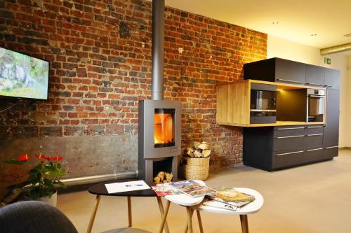 a living room with a brick wall and a fireplace at Gîte La Siroperie in Wanze
