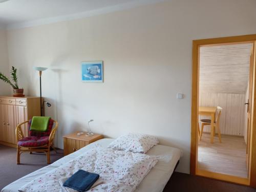 1 dormitorio pequeño con 1 cama y 1 silla en Apartmán Zahrádka en Česká Lípa