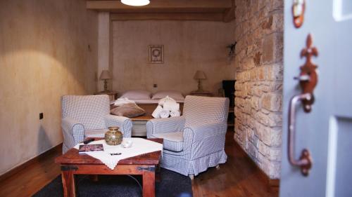 a room with chairs and a bed with a table at Artsistas Houses in Aristi