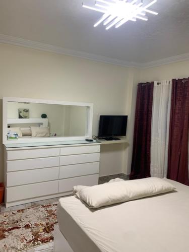 a bedroom with a bed and a dresser with a mirror at Paris st in Ismailia