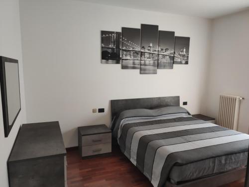 1 dormitorio con 1 cama y una pared con pinturas en Veronica's Home, en Bérgamo