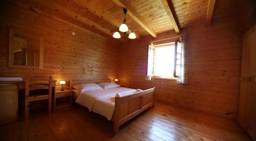 a bedroom with a bed in a wooden room at Holiday Homes Eko Klanac in Rakovica