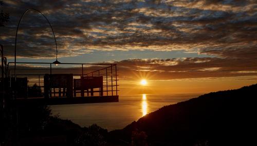 a sunset over the water with the sun in the sky at Sunrise Garden Hills in Makrirrákhi