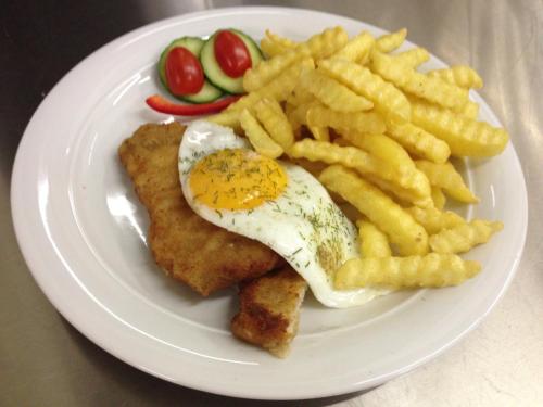 a plate of food with an egg and french fries at Hotel & Restaurant Druidenstein in Trautenstein