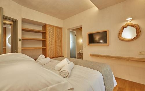 a bedroom with a white bed with towels on it at Sunrise Garden Hills in Makrirrákhi