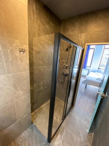 a shower with a glass door in a bathroom at Lift Rooms - Derybasivska in Odesa