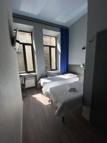 two beds in a room with two windows at Lift Rooms - Derybasivska in Odesa