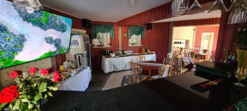 a living room with a television and a table with red flowers at Apartament Hexagon nr 36 in Grzybowo