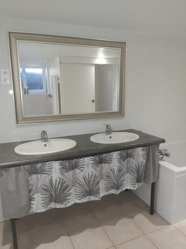 a bathroom with two sinks and a mirror at Grand studio tout équipé in Ploërmel