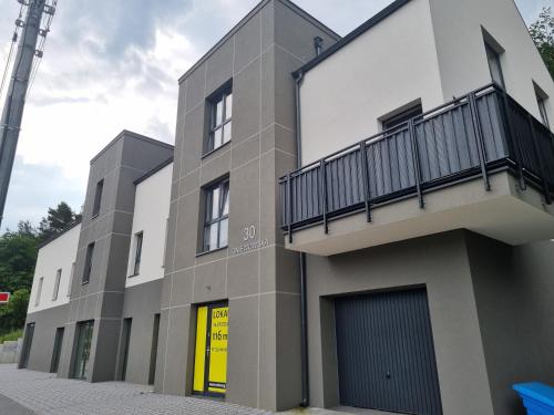 a building with a balcony on the side of it at Komfortowy apartament przy lesie in Wejherowo