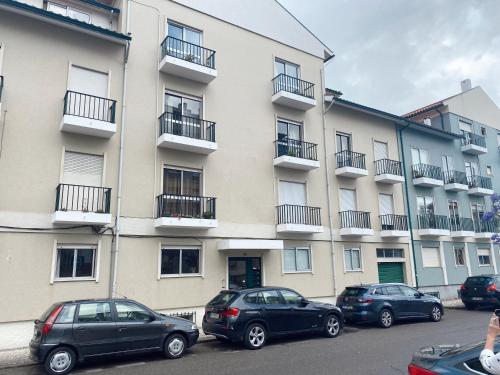 un groupe de voitures garées devant un bâtiment dans l'établissement Mima House Al, à Aveiro