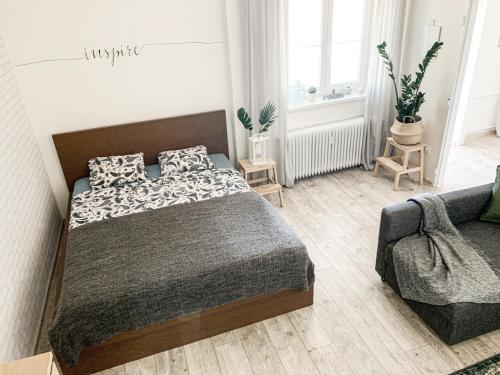 een slaapkamer met een bed en een bank bij Charming Apartment in Paradise called Bratislava in Bratislava