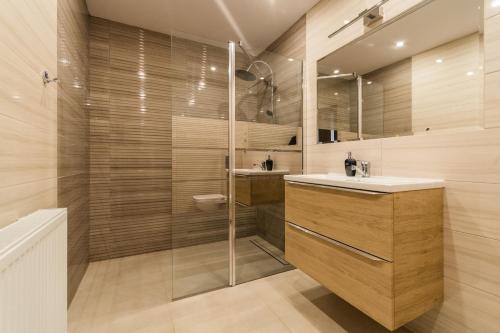 a bathroom with a shower and a sink and a mirror at Cavilla - Pokoje i Apartamenty in Sztutowo