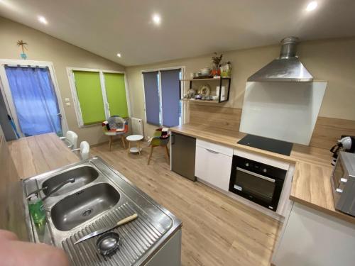 une cuisine avec un évier et une cuisinière four supérieur dans l'établissement Gîte cosy en milieu rural, à Lavilleneuve-au-Roi