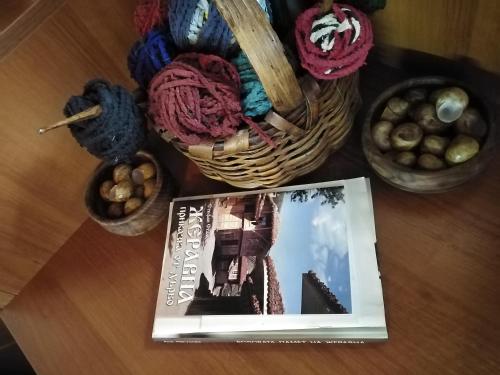 a book sitting on a table with yarn and baskets at Къща за гости УЮТ с. Жеравна in Zheravna