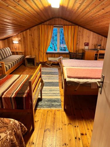 a room with two beds and a couch at Christinagårdens stuga in Ramsele