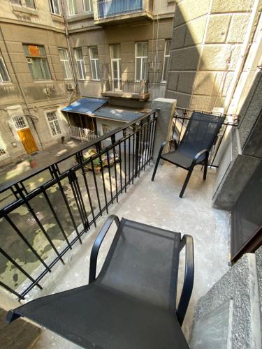 a balcony with two black benches and a building at Lift Rooms - Derybasivska in Odesa