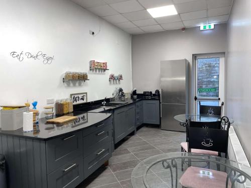 a kitchen with gray cabinets and stainless steel appliances at Atlantic Lodge, Main Street Ardara in Ardara